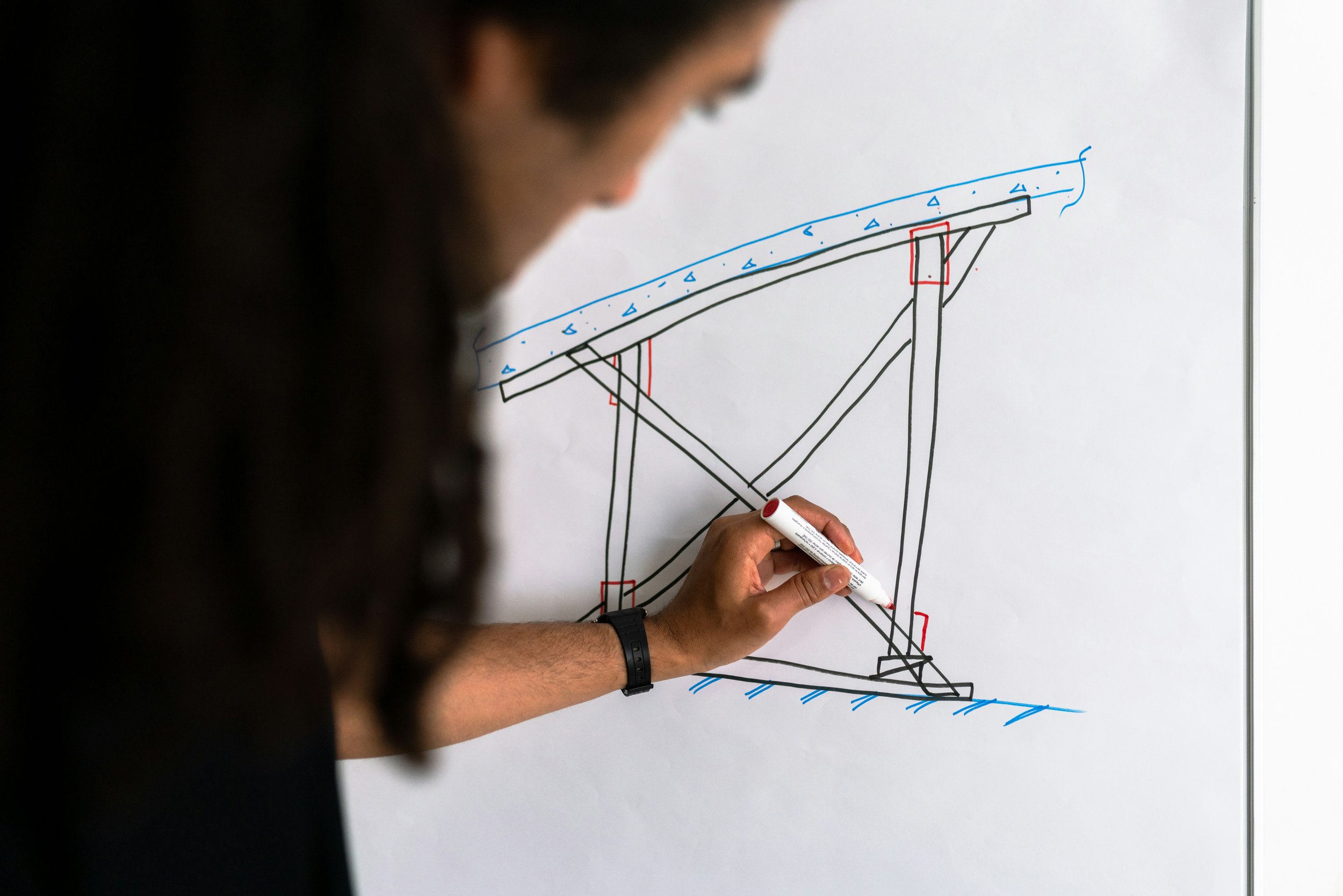 A photograph of a designer drawing on a whiteboard